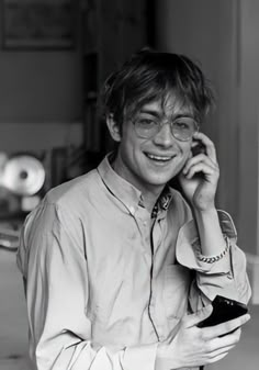 black and white photograph of a young man talking on his cell phone while wearing glasses