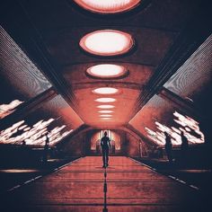 a man is standing in the middle of a tunnel with bright lights on either side