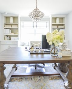 an instagram photo of a living room and dining room with white flowers on the table