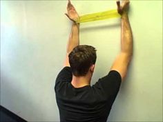 a man is measuring the wall with tape