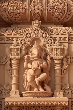 an intricately carved ganeshi sculpture on the side of a building in india