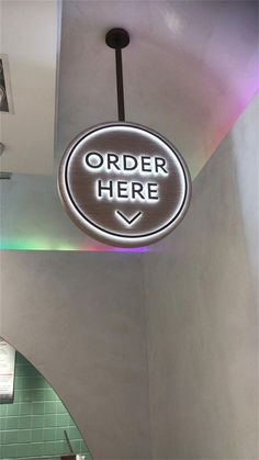 there is a sign that says order here hanging from the ceiling