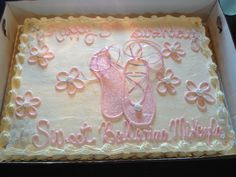 a sheet cake decorated with pink and white icing in a box on top of a table