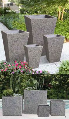 four cement planters sitting next to each other in front of some bushes and flowers