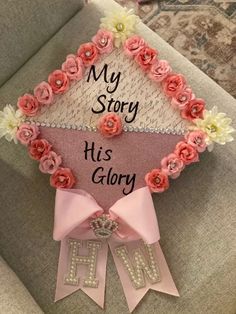 a pink graduation cap with flowers on it and the words my story is his glory