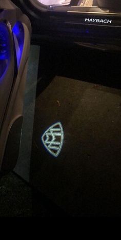 the interior of a car is lit up with blue lights and logo on the door