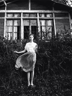 a woman standing in front of an old house