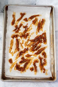 bacon strips on a baking sheet ready to go into the oven for making chicken wings