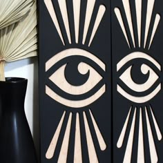 an eye is on the wall next to a vase