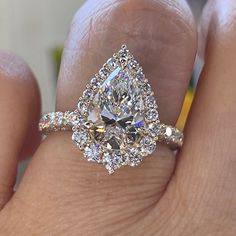 a woman's hand with a diamond ring on top of her finger and an engagement band