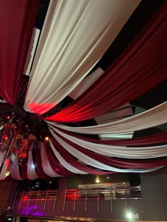 the ceiling is decorated with red, white and black draping for an event