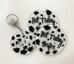 two key chains with black and white designs on them that say hot today, hot today, hot friday, hugger