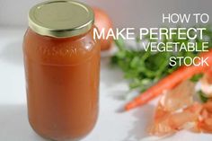 a mason jar filled with carrots next to some veggies on a table