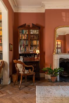 a living room filled with furniture and a fire place in front of a book shelf