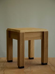 a small wooden stool sitting on top of a hard wood floor