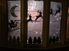 a lighted window with santa's sleigh and reindeer on it