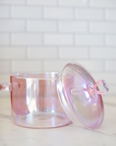 a pink glass container sitting on top of a white counter