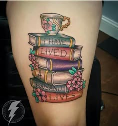 a tattoo on the leg of a woman with books and a coffee cup sitting on top of it