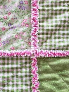 a close up view of a quilt with pink and green flowers on the edges,