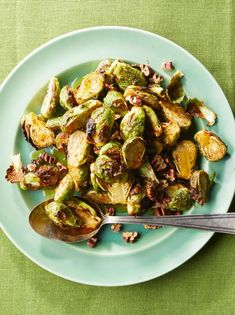 brussel sprouts on a blue plate with a spoon next to it