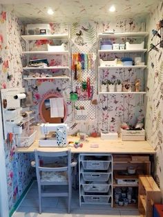 a sewing room with lots of crafting supplies on the desk and shelves above it