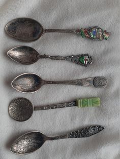 six spoons are lined up on a white cloth