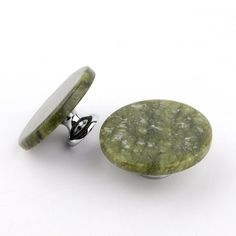 a pair of green stone cufflinks and a button