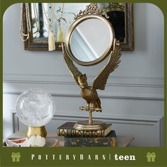 a mirror sitting on top of a table next to a book and a crystal ball