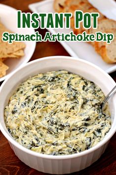 spinach artichoke dip in a white bowl with crackers on the side