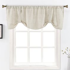 a window with a white curtain and some pictures on the wall