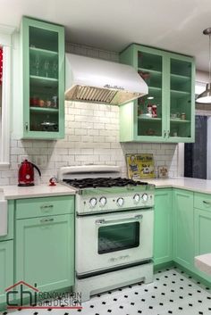 a kitchen with mint green cabinets and white tile flooring on the walls, along with a stove top oven