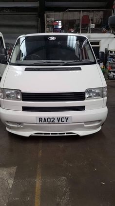 the front end of a white van parked in a garage