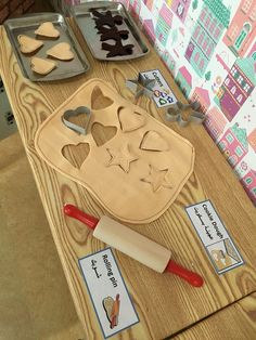 a wooden table topped with cookie cutters and other baking supplies on top of it