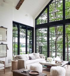 a living room filled with furniture and lots of windows on top of the walls next to each other