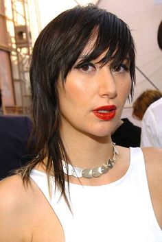 a woman with black hair and red lipstick