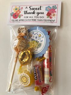 a candy bag filled with assorted candies and chocolates next to a thank you sign