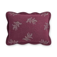 a purple pillow with embroidered leaves on it