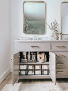 a bathroom vanity with drawers and a mirror on the wall above it that is filled with clear containers