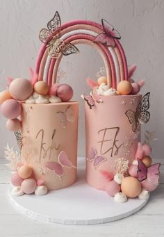 two pink vases sitting on top of a white table next to each other with butterflies