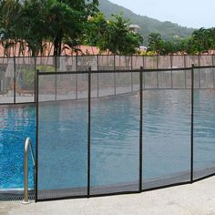 a fenced in swimming pool surrounded by palm trees