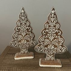 two decorative wooden christmas trees sitting on top of a table