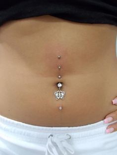 a woman's stomach with three piercings on it