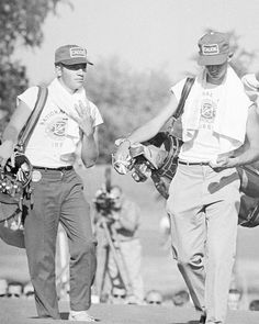 two baseball players are walking down the field with their gloves on and one is holding a catcher's mitt