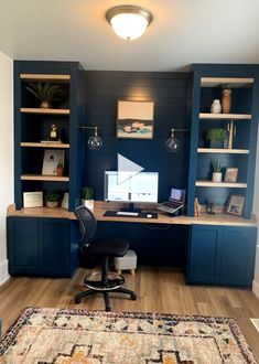 a home office with built - in shelving, desk and rug on the floor