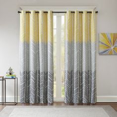 a living room with yellow and gray drapes on the window sill, rug and painting