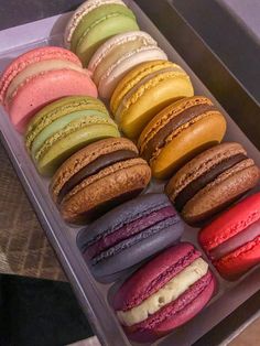 a plastic container filled with lots of different colored macaroons