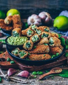 some food is on a wooden table with garlic and limes in the back ground