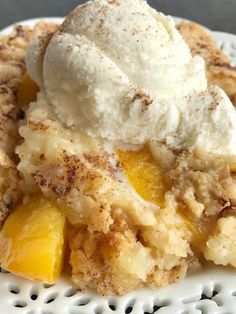 a white plate topped with fruit cobbler and ice cream covered in powdered sugar