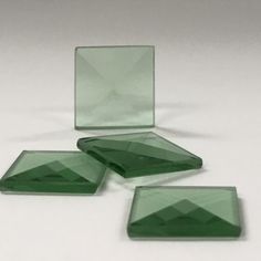 three green glass plates sitting on top of a white table