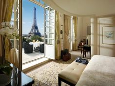 a bedroom with a view of the eiffel tower from it's window